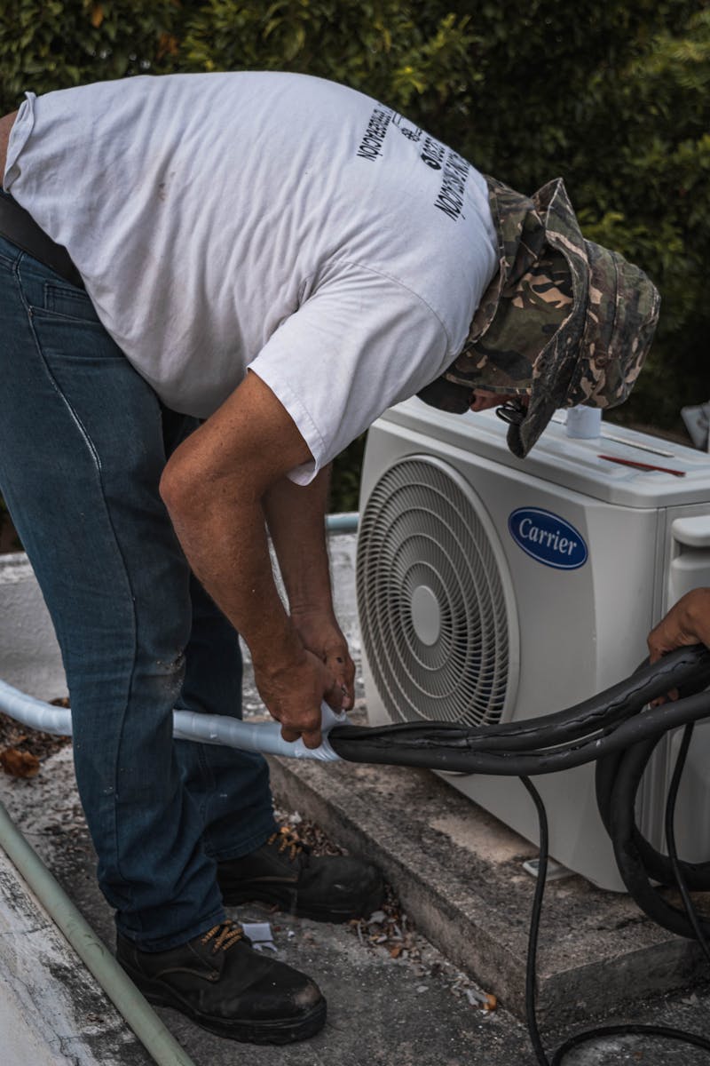 HVAC technician installing AC condenser